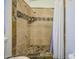 Shower with tan tiling and dark tiling accents at 9967 W Devonshire Ave, Phoenix, AZ 85037