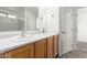 A full bathroom features a double sink vanity with wooden cabinets and a large mirror at 999 S Sabino Dr, Gilbert, AZ 85296