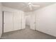A bedroom features neutral walls, carpet, and a ceiling fan, plus doors to the hallway and closet at 999 S Sabino Dr, Gilbert, AZ 85296