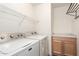 Bright laundry room features a washer, dryer, storage cabinet, and wire shelving for efficient organization at 999 S Sabino Dr, Gilbert, AZ 85296