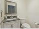 Half bathroom featuring a sink with white cabinets, a mirror, and a toilet at 1014 S Porter St, Gilbert, AZ 85296