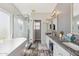 Bright bathroom featuring a soaking tub, glass shower, granite counters, and double sinks at 1014 S Porter St, Gilbert, AZ 85296