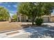 One-story home featuring a desert landscape, shade tree, and driveway at 1014 S Porter St, Gilbert, AZ 85296