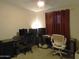 Bedroom with multiple computer workstations and a brown curtain in a neutrally painted room at 10201 S 49Th St, Phoenix, AZ 85044