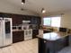 Well-lit kitchen with dark cabinets, white appliances, and a functional layout for cooking and entertaining at 10201 S 49Th St, Phoenix, AZ 85044