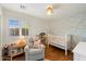 Charming Bedroom with hardwood floors, rocking chair, and a white crib with cute wallpaper at 10239 E Salt Bush Dr, Scottsdale, AZ 85255
