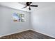 Cozy bedroom featuring a ceiling fan, window view, and laminate flooring at 1027 S Lola Ln, Tempe, AZ 85281