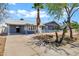 Attractive home featuring desert landscaping, covered parking, and gray brick accenting the facade at 1027 S Lola Ln, Tempe, AZ 85281