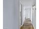 Bright hallway with wood flooring leading to multiple rooms and closets with white doors at 1027 S Lola Ln, Tempe, AZ 85281