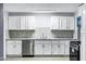 Modern kitchen featuring white cabinetry, stainless steel appliances, and a mosaic backsplash at 1027 S Lola Ln, Tempe, AZ 85281