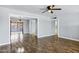 Open-concept living room with wood flooring, ceiling fan and open doorway to additional living spaces at 1027 S Lola Ln, Tempe, AZ 85281