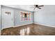 Bright living room boasts wood floors, natural light from a large bay window, and a white door at 1027 S Lola Ln, Tempe, AZ 85281