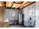 Functional utility room with a water heater, storage, and painted paneling with brick foundation at 1027 S Lola Ln, Tempe, AZ 85281