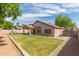 Spacious backyard with lush lawn, covered patio, play structure, and block fence at 1028 W Chilton Ave, Gilbert, AZ 85233