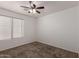 Bedroom boasts a ceiling fan and a window with blinds for pleasant natural light at 1028 W Chilton Ave, Gilbert, AZ 85233