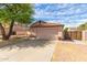 Single-story home featuring an attached two-car garage, desert landscaping, and a private gated entry at 1028 W Chilton Ave, Gilbert, AZ 85233