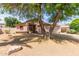 Single-story home with desert landscaping, a covered entryway, and beautiful mature shade trees at 1028 W Chilton Ave, Gilbert, AZ 85233