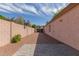 Side yard with gravel and a paved patio area, enclosed by a block wall at 1028 W Chilton Ave, Gilbert, AZ 85233