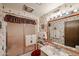 Well-lit bathroom with a shower, floral wallpaper, and decorative towels and fixtures at 10401 W Loma Blanca Dr, Sun City, AZ 85351