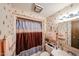 Compact bathroom showcasing essential fixtures including a vanity, toilet, shower, and patterned wallpaper at 10401 W Loma Blanca Dr, Sun City, AZ 85351