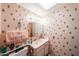 Cozy bathroom featuring a single sink vanity, tiled floors, and a patterned wall with neutral tones at 10401 W Loma Blanca Dr, Sun City, AZ 85351