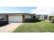 A single-story home featuring an attached two-car garage, lush landscaping, and a manicured front lawn at 10401 W Loma Blanca Dr, Sun City, AZ 85351