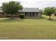 Backyard view of a home with well manicured lawn and trees at 10428 W Camelot Cir, Sun City, AZ 85351