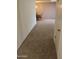 Hallway that leads to a dining room with carpet flooring and neutral wall paint at 10428 W Camelot Cir, Sun City, AZ 85351