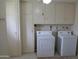 Functional laundry room with washer, dryer, and ample storage cabinets at 10428 W Camelot Cir, Sun City, AZ 85351