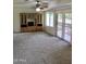 Spacious living room with built-in shelving, neutral carpet, and sliding doors to patio at 10428 W Camelot Cir, Sun City, AZ 85351