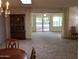 Open-concept living room with neutral carpet, chandelier, and sliding doors to patio at 10428 W Camelot Cir, Sun City, AZ 85351