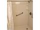 Shower with white showerhead, grab bar and white patterned shower curtain at 10428 W Camelot Cir, Sun City, AZ 85351