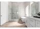 Bright and airy bathroom featuring a glass walk-in shower, soaking tub, dual sink vanity, and neutral tile flooring at 11662 E Parkview Ln, Scottsdale, AZ 85255