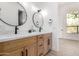 Elegant bathroom featuring double vanity with wood cabinets, stone countertop, and modern fixtures at 11662 E Parkview Ln, Scottsdale, AZ 85255
