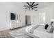 Spacious bedroom with stylish dresser, art, ceiling fan, and an adjacent bathroom with glass shower at 11662 E Parkview Ln, Scottsdale, AZ 85255