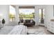 Bright bedroom with a cozy seating area overlooking the pool and desert landscape at 11662 E Parkview Ln, Scottsdale, AZ 85255
