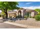 Charming desert home with a light tan exterior, rock landscaping, mature trees, and a two-car garage at 11662 E Parkview Ln, Scottsdale, AZ 85255
