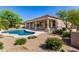 Backyard view of a sparkling pool and covered patio surrounded by lush landscaping at 11662 E Parkview Ln, Scottsdale, AZ 85255