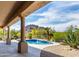 Outdoor pool with rock features surrounded by lush landscaping with mountain views from a covered patio at 11662 E Parkview Ln, Scottsdale, AZ 85255