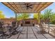Inviting backyard patio featuring dining and relaxing seating options, a covered pergola and a stone fireplace at 12325 S 179Th S Ave # 0, Goodyear, AZ 85338