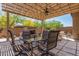 Inviting backyard patio features dining and relaxing seating options, a covered pergola and a stone fireplace at 12325 S 179Th S Ave # 0, Goodyear, AZ 85338