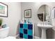 Bathroom with pedestal sink, decorative storage, and artwork at 12325 S 179Th S Ave # 0, Goodyear, AZ 85338