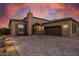 Exterior view of a cozy home with desert landscaping, paver driveway, and a beautiful facade, with warm lighting at 12325 S 179Th S Ave # 0, Goodyear, AZ 85338