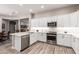 Bright kitchen with stainless steel appliances, white cabinets, and hardwood floors at 12325 S 179Th S Ave # 0, Goodyear, AZ 85338
