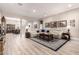 Inviting living room with a large sectional, wood-look floors, and stylish decor, open to dining area at 12325 S 179Th S Ave # 0, Goodyear, AZ 85338