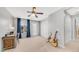 Spacious bedroom with natural light and a ceiling fan, staged with a desk and musical instruments at 1250 N Abbey Ln # 275, Chandler, AZ 85226
