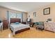 Cozy bedroom filled with natural light from large windows featuring hardwood floors and traditional decor at 13418 N 108Th Dr, Sun City, AZ 85351