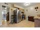 Efficient kitchen featuring tile flooring, stainless steel refrigerator, oak cabinets, and ample counter space at 13418 N 108Th Dr, Sun City, AZ 85351