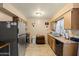 Functional kitchen with granite counters, stainless steel refrigerator, tile flooring, and oak cabinets at 13418 N 108Th Dr, Sun City, AZ 85351