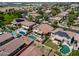 An aerial view highlights a neighborhood featuring houses with backyard pools, solar panels, and verdant landscaping at 13965 N 135Th Dr, Surprise, AZ 85379